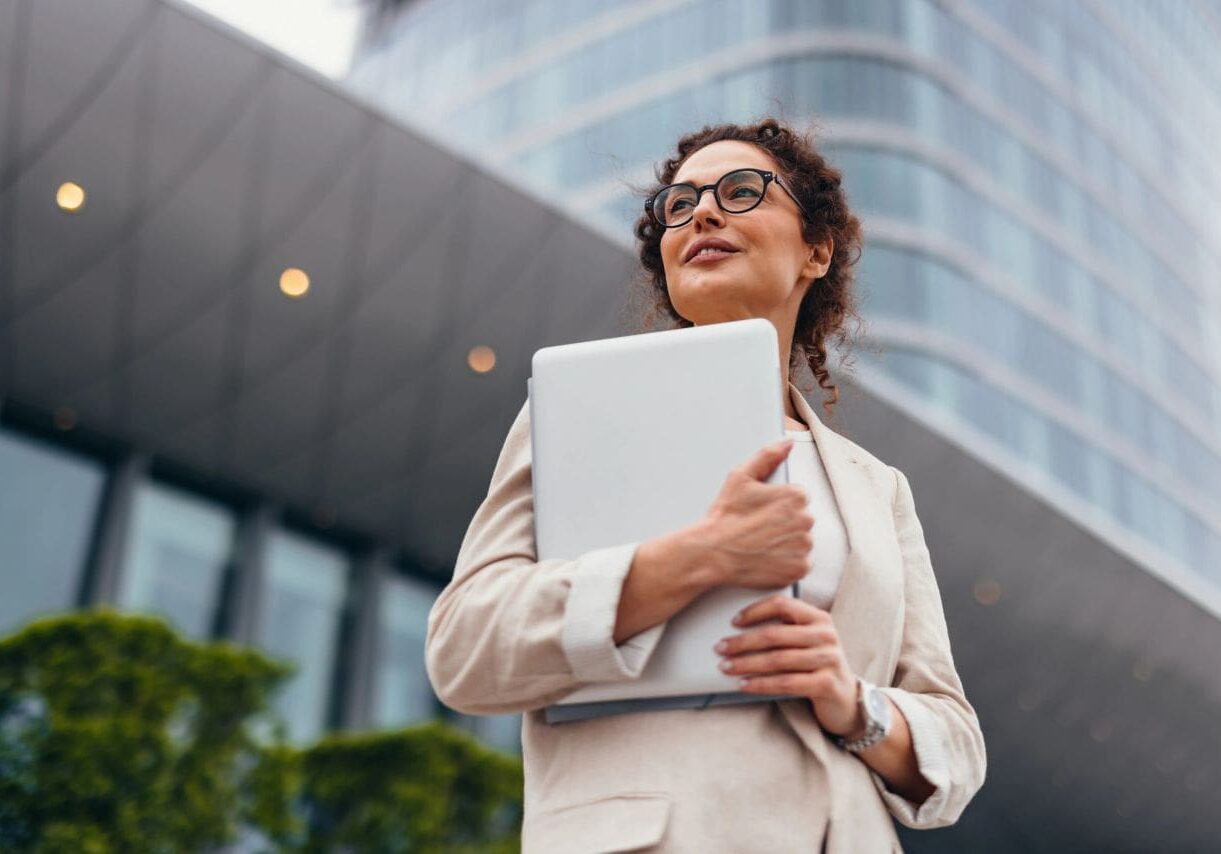 Confident executive standing near office complex